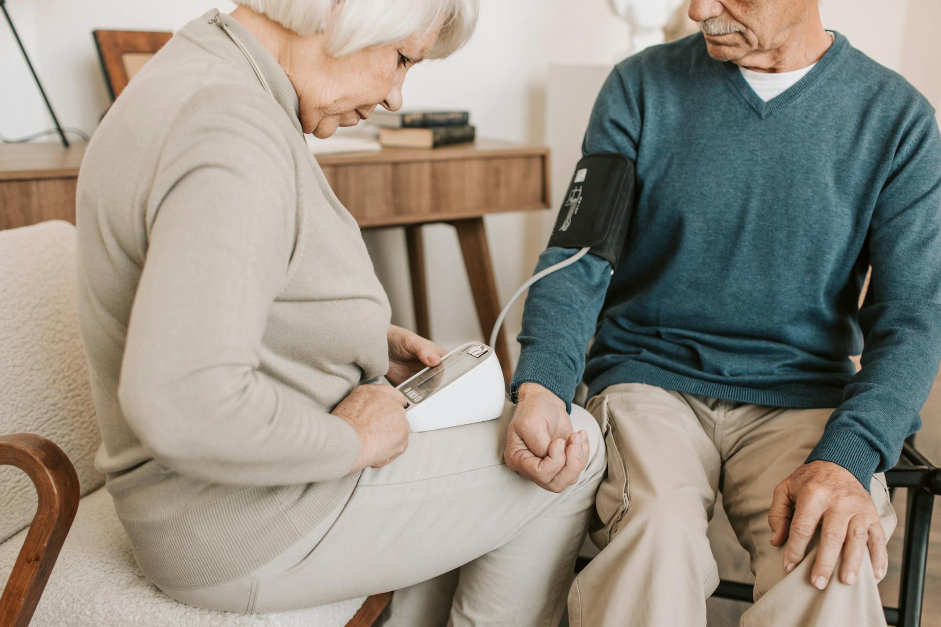 An older couple checking blood pressure at home