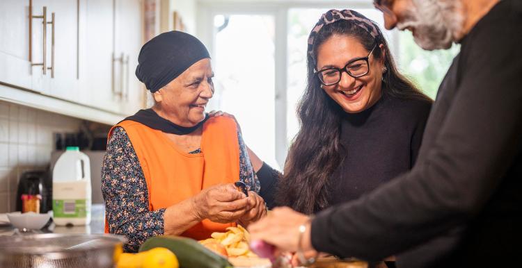 Lady helping her elderly parents prepare dinner