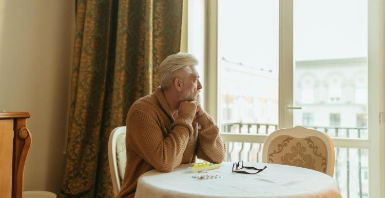 A male sitting at a table looking out of the window