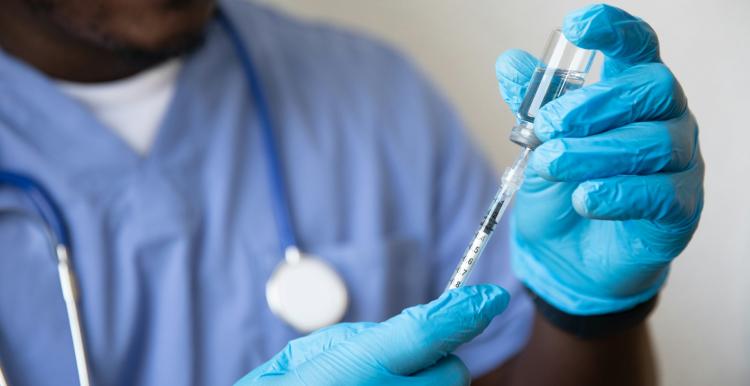 A vaccination being prepared by a male nurse