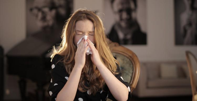 Women sneezing into a tissue