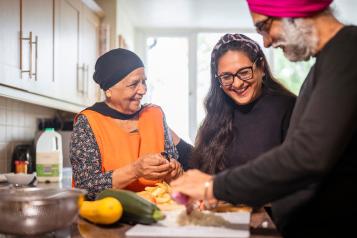 Lady helping her elderly parents prepare dinner