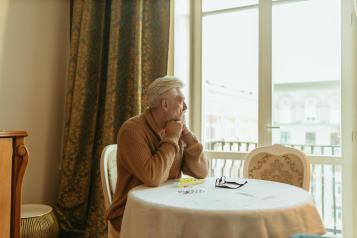 A male sitting at a table looking out of the window