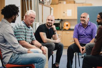 Group of men sitting in a circle chatting