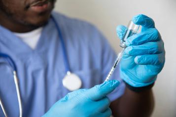 A vaccination being prepared by a male nurse